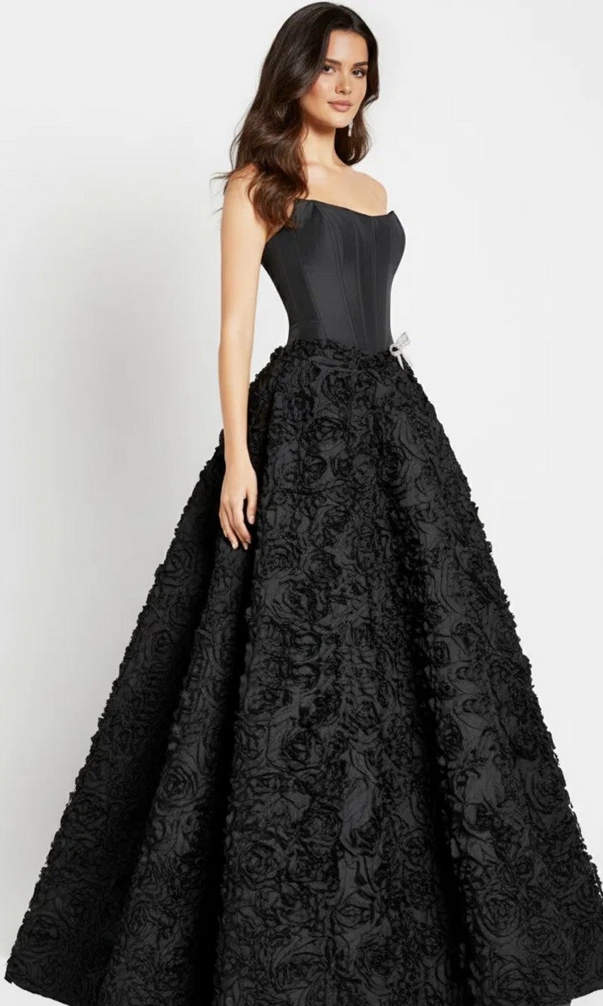 A woman in the Jovani 47695 long prom dress with a strapless corset bodice and a flowing 3D rosette skirt.